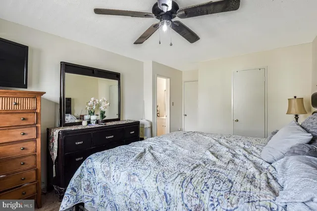 a bedroom with a bed and a mirror on dresser