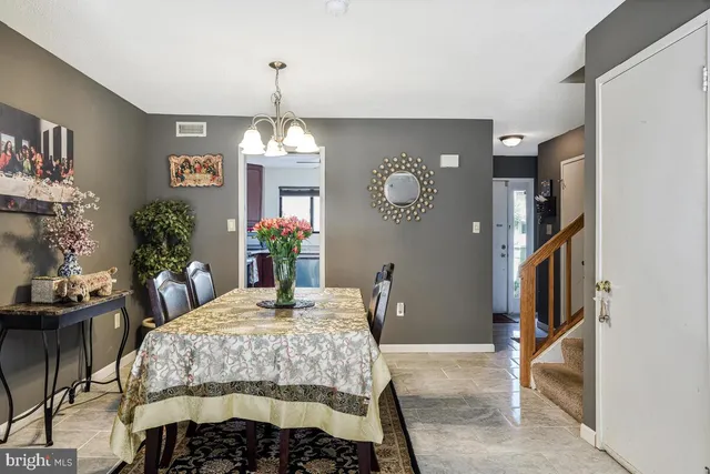 a bedroom with a bed a chandelier and dresser