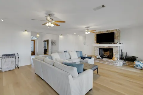 a view of a dining room and livingroom with furniture wooden floor a chandelier