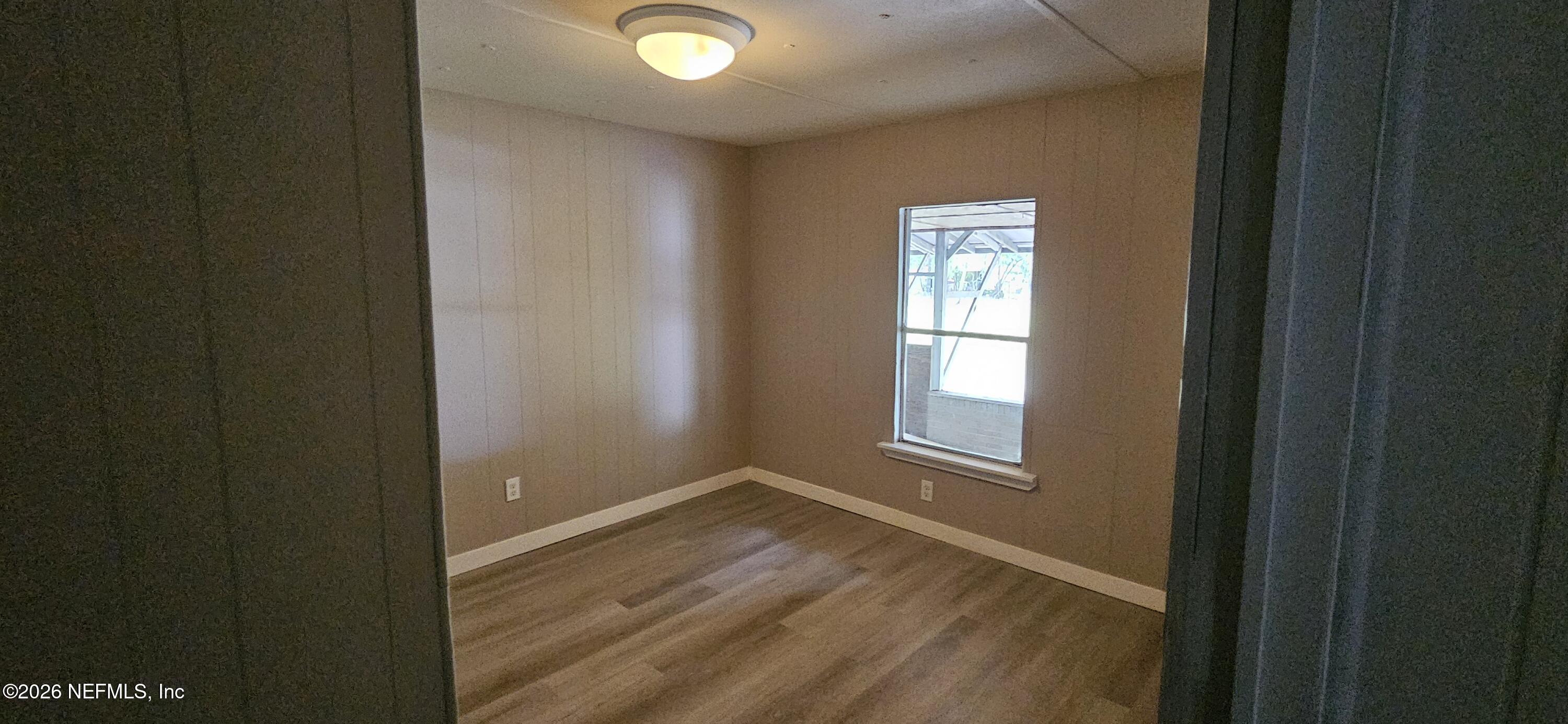 5363 Kilcrease Road Jacksonville, FL 32234 - Photo 11 of 29 a view of an empty room with wooden floor and a window