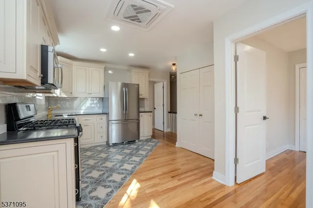 a kitchen with stainless steel appliances granite countertop a refrigerator and a stove top oven