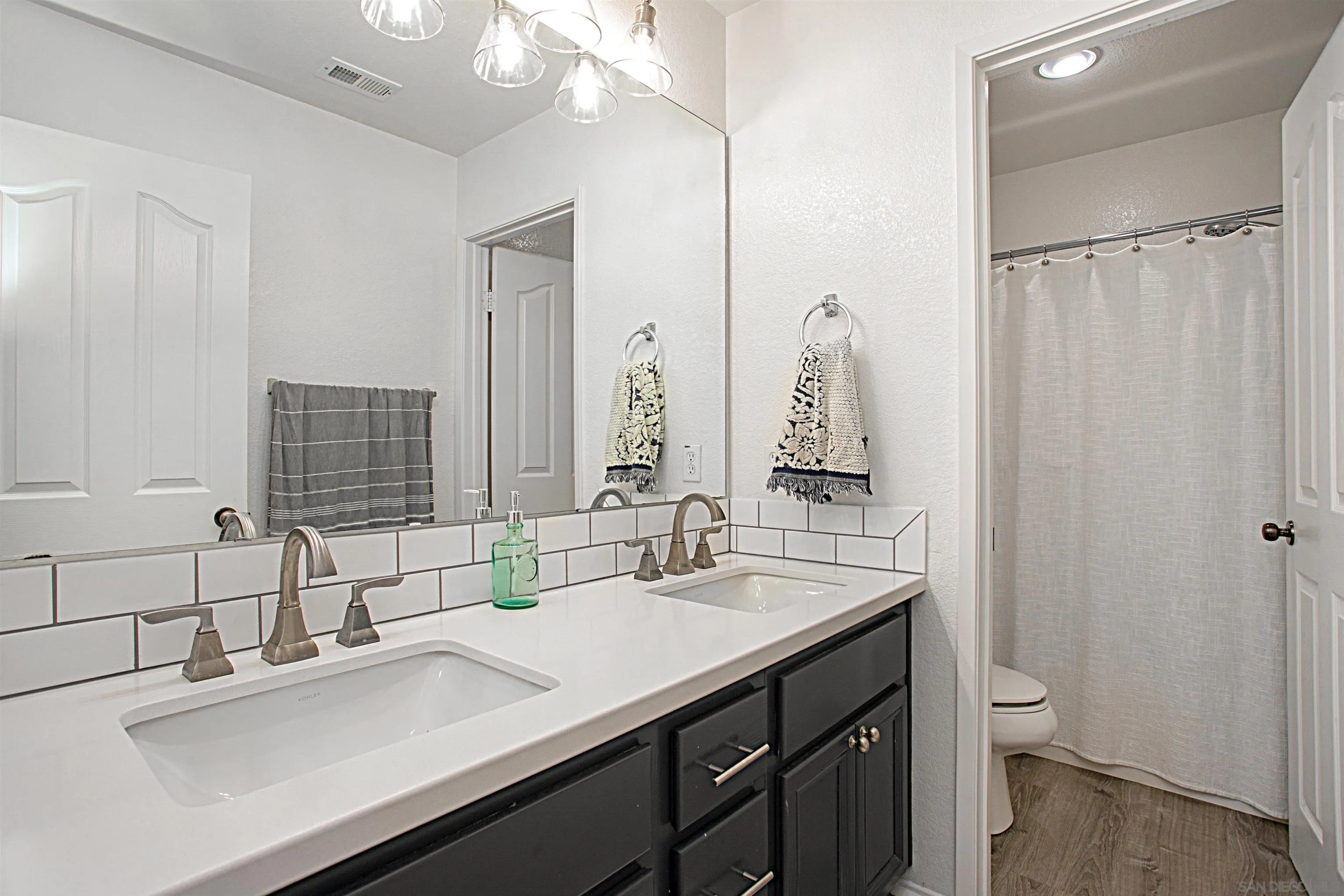 1091 Greenway Road Oceanside, CA 92057 - Photo 21 of 26 a bathroom with a double vanity sink and a mirror