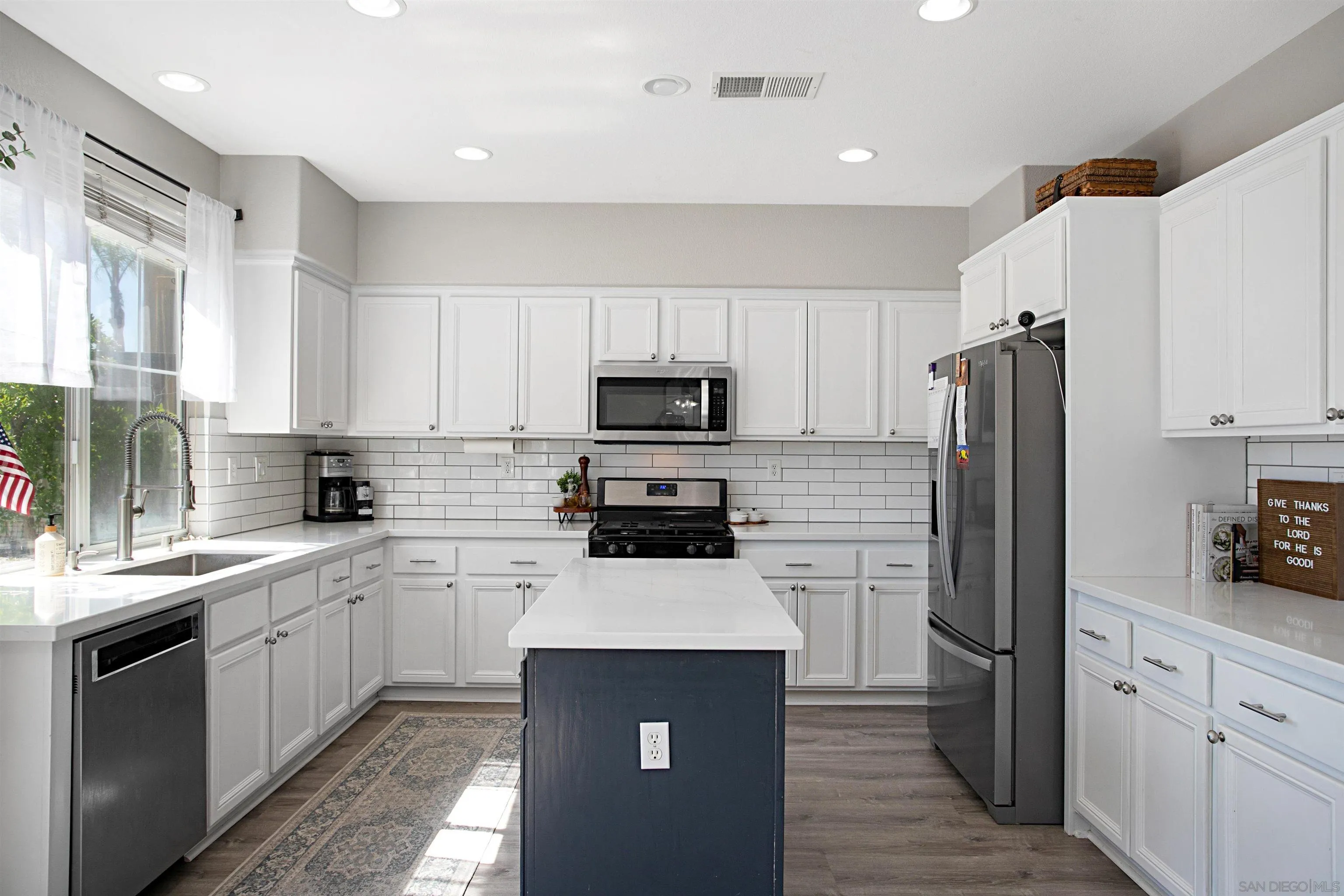 1091 Greenway Road Oceanside, CA 92057 - Photo 5 of 26 a kitchen with a sink white cabinets and stainless steel appliances