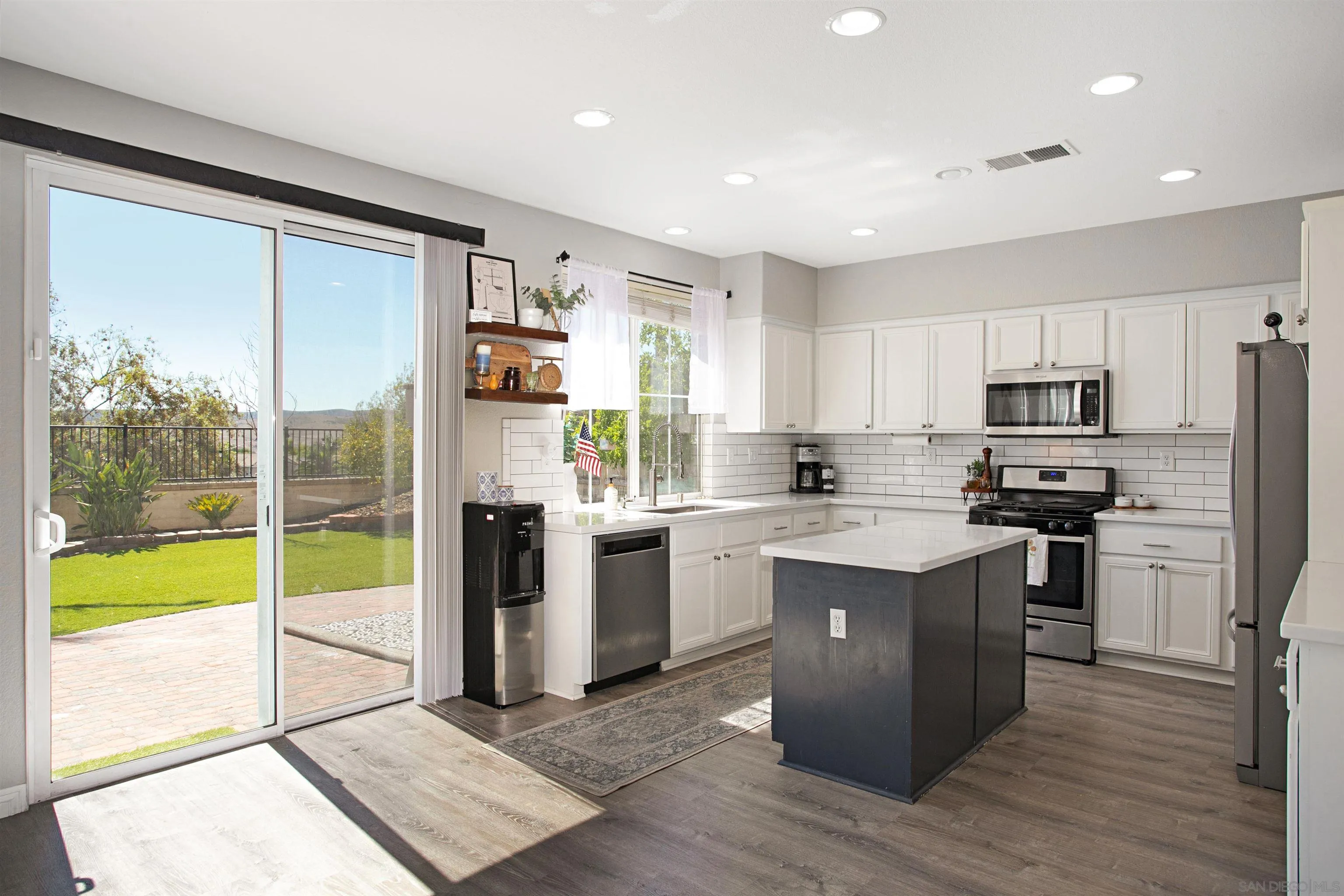 1091 Greenway Road Oceanside, CA 92057 - Photo 8 of 26 a kitchen with a refrigerator and a stove top oven