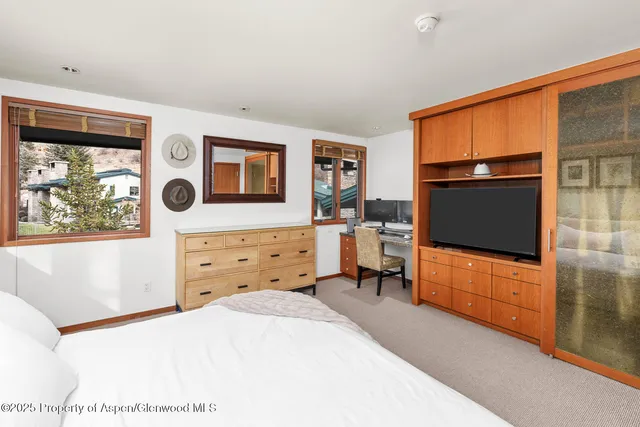 a bedroom with a bed and a flat screen tv