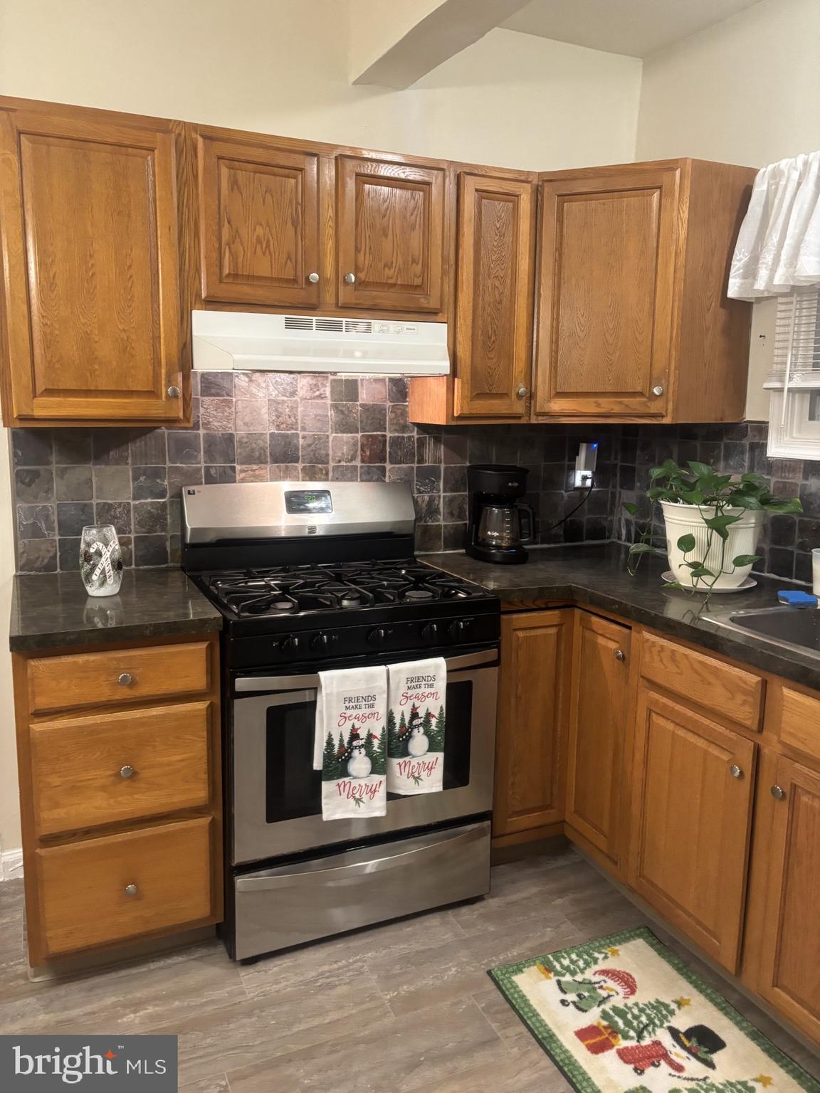 4907 Rawle Street Philadelphia, PA 19135 - Photo 10 of 24 a kitchen with stainless steel appliances granite countertop a stove a sink and a microwave