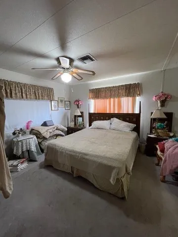a spacious bedroom with a bed and a chandelier