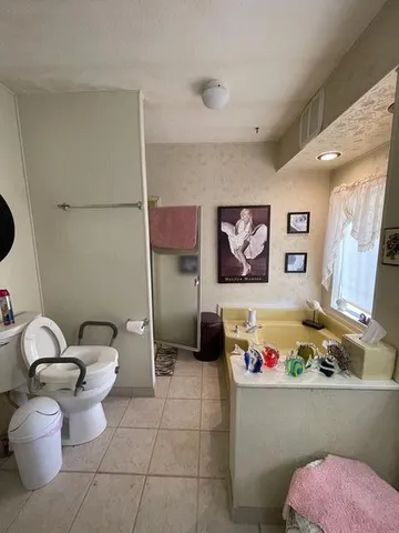 a bathroom with a granite countertop sink mirror vanity and toilet