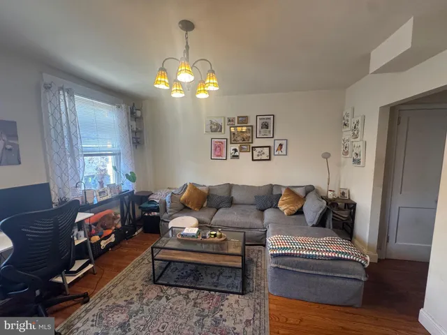 a living room with furniture chandelier and a window