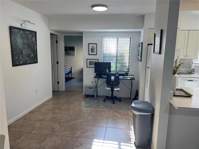 a living room with furniture a flat screen tv and kitchen view