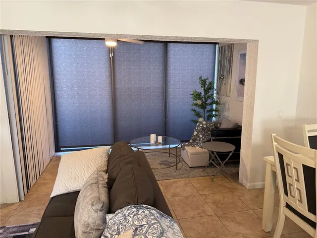 a living room with furniture a dining table and a potted plant