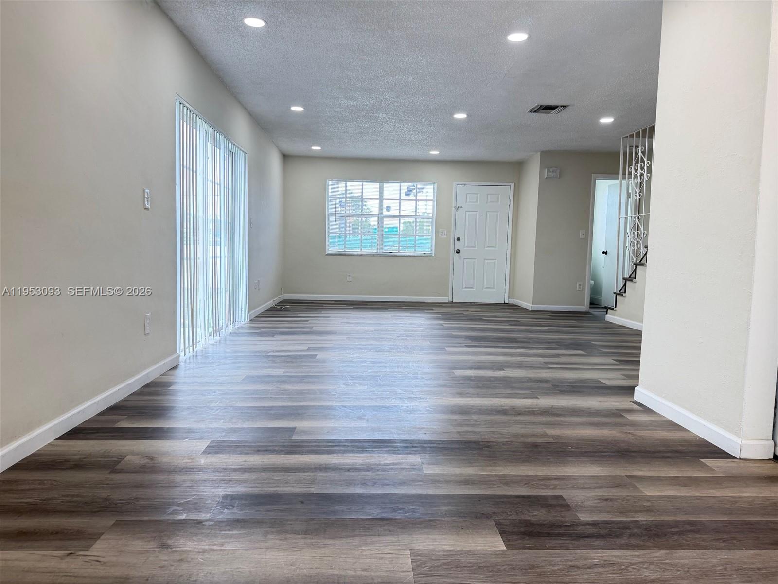 9503 Southwest 88th Terrace, Unit 9503 Miami, FL 33176 - Photo 2 of 15 an empty room with wooden floor and windows