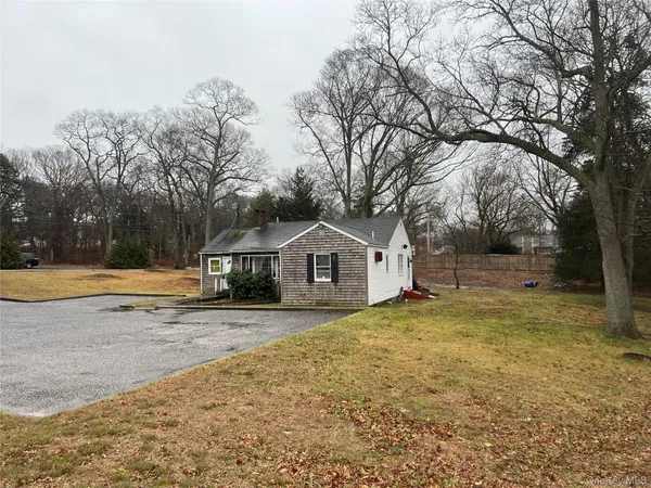 a view of a yard with a large tree in front of it
