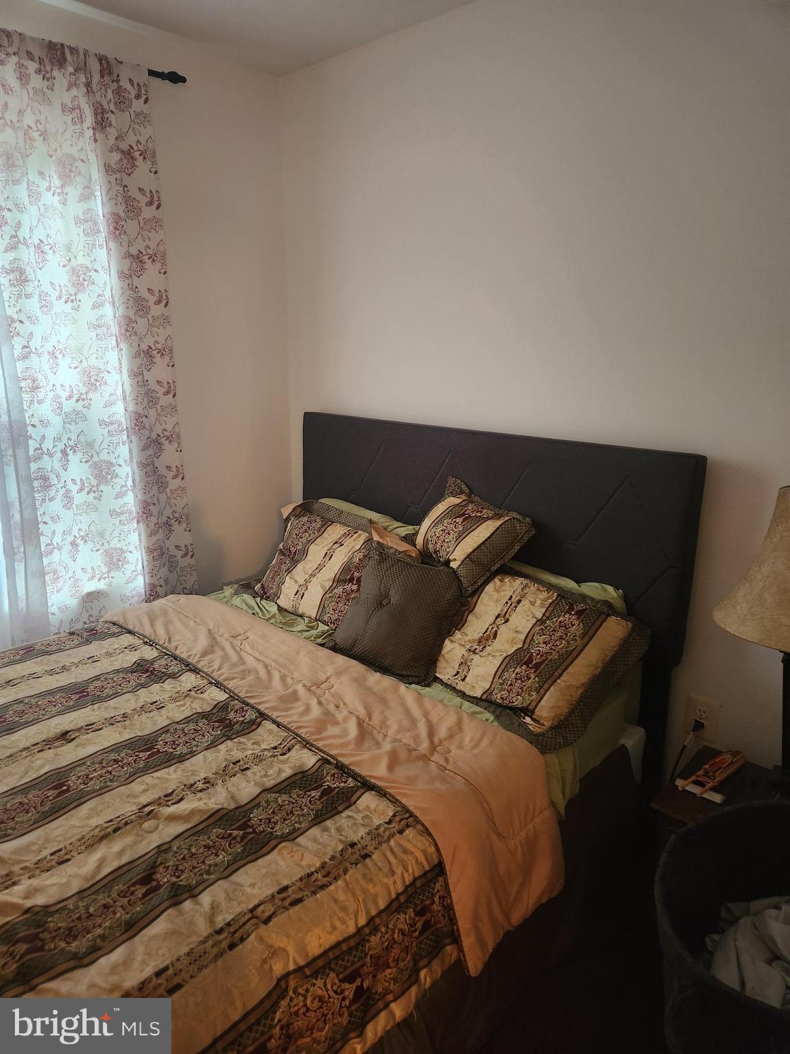 12912 Boggy Trail Way, Unit 55 Germantown, MD 20876 - Photo 19 of 27 a bed sitting in a bedroom next to a window with a lamp