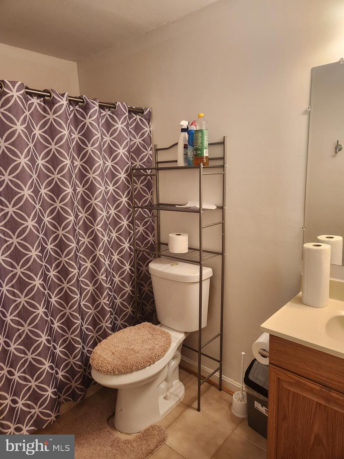 12912 Boggy Trail Way, Unit 55 Germantown, MD 20876 - Photo 26 of 27 a white toilet sitting next to a shower curtain