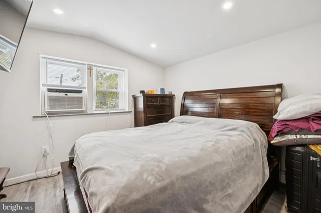 a bedroom with a bed and wooden floor