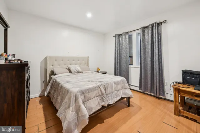 a bedroom with a bed and a flat tv screen on a dresser
