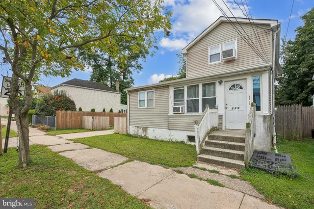 a view of a house with a yard and large tree