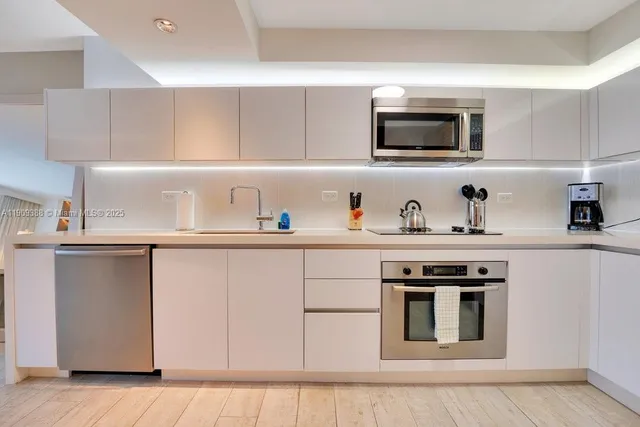 a kitchen with stainless steel appliances a stove microwave and sink