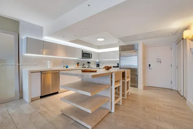 a kitchen with a refrigerator and white cabinets