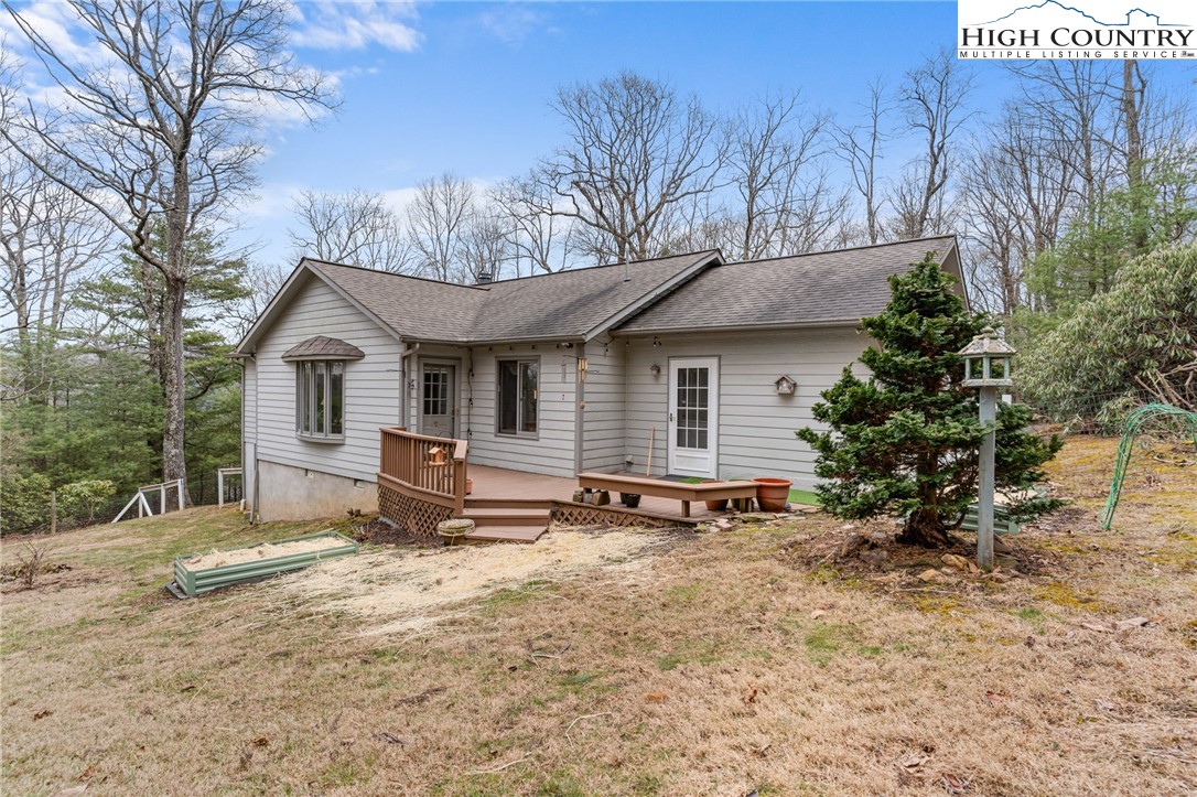 120 Village Road Glade Valley, NC 28627 - Photo 6 of 30 a backyard of a house with table and chairs under an umbrella
