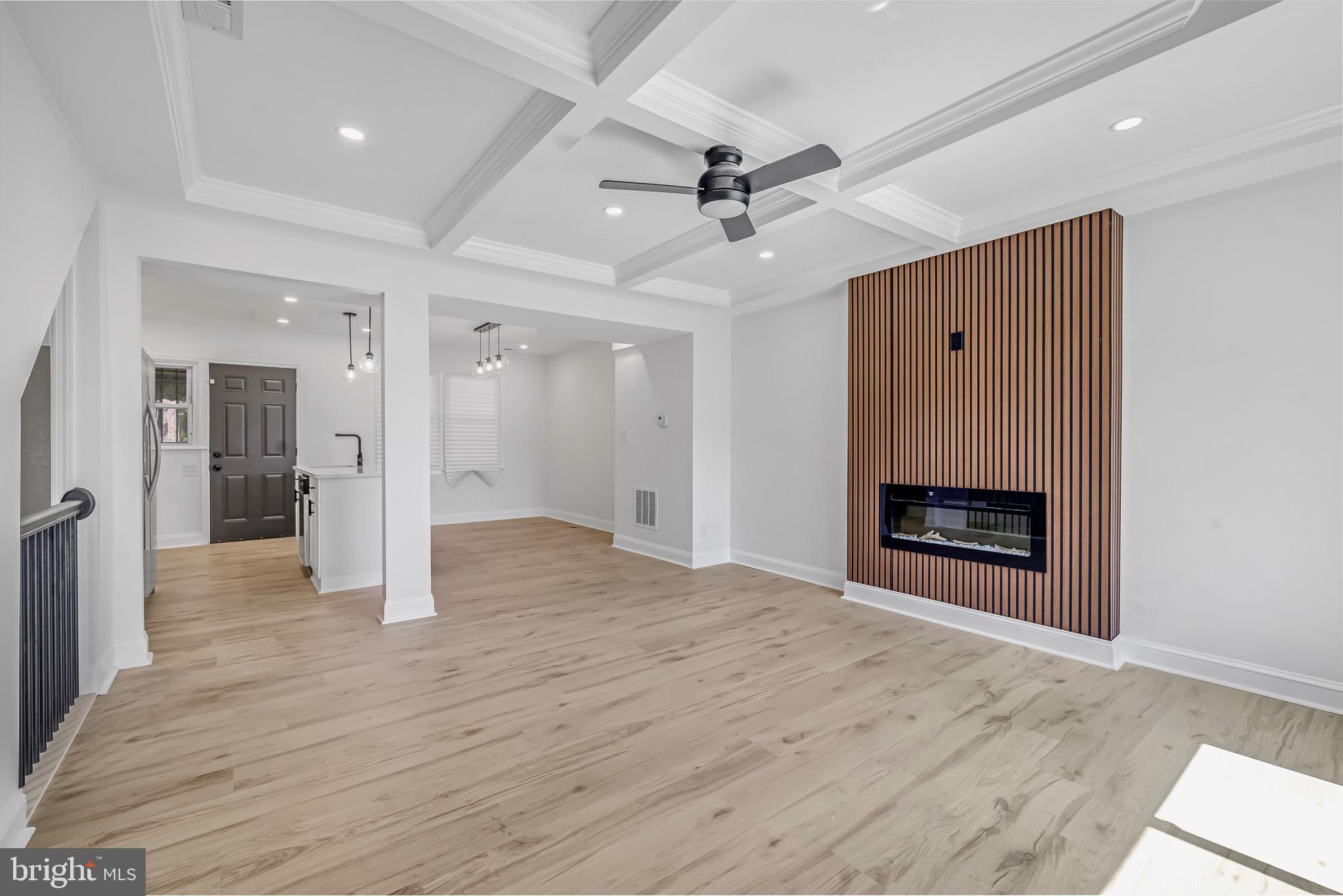 840 Benninghaus Road Baltimore, MD 21212 - Photo 5 of 30 a view of a livingroom with a fireplace a ceiling fan and kitchen space