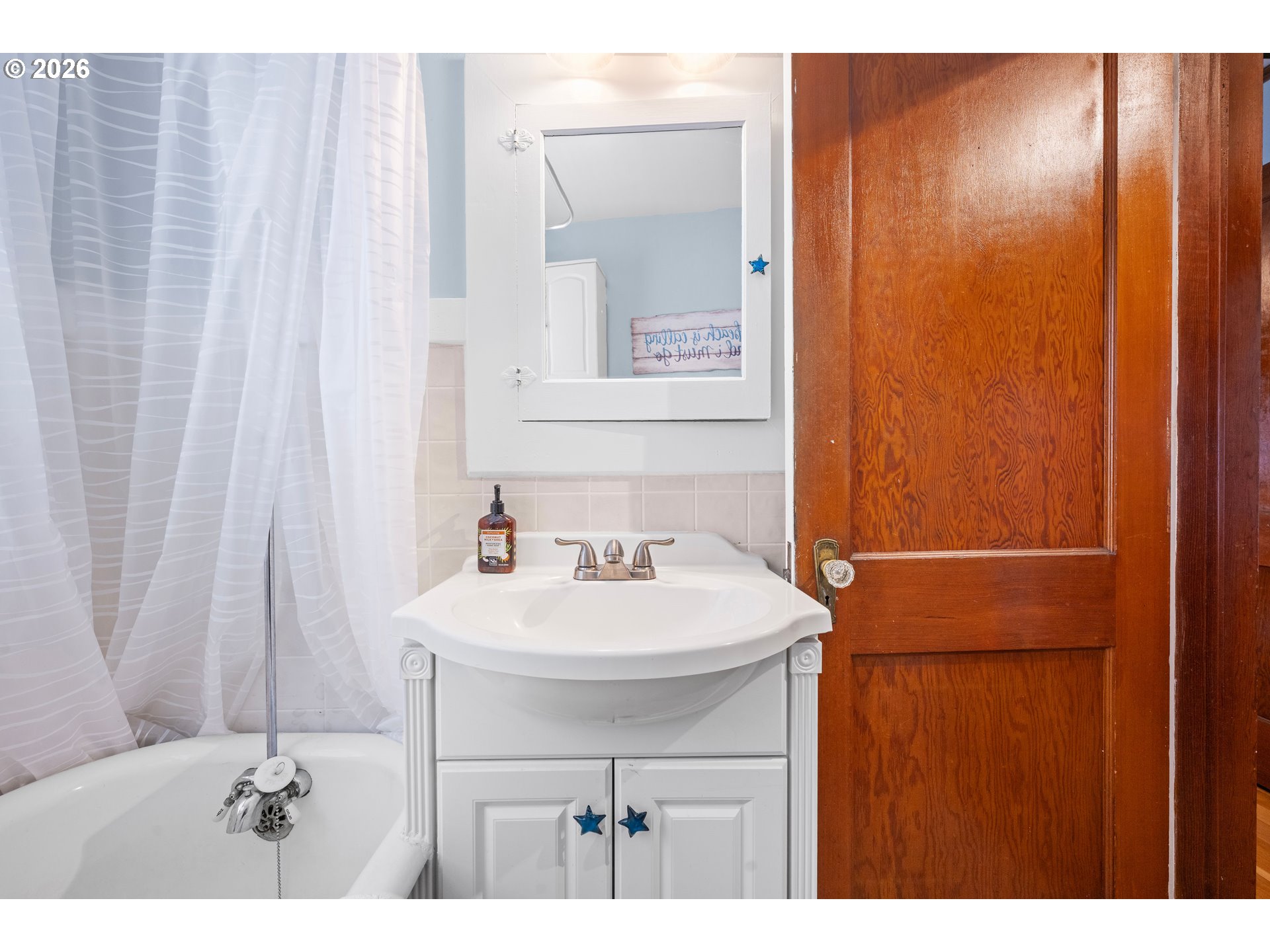 416 South Downing Street Seaside, OR 97138 - Photo 36 of 48 a bathroom with a sink a mirror and a shower curtain