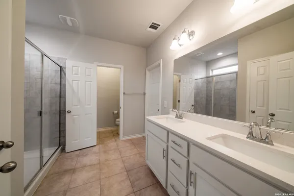 a spacious bathroom with a double vanity sink mirror and double