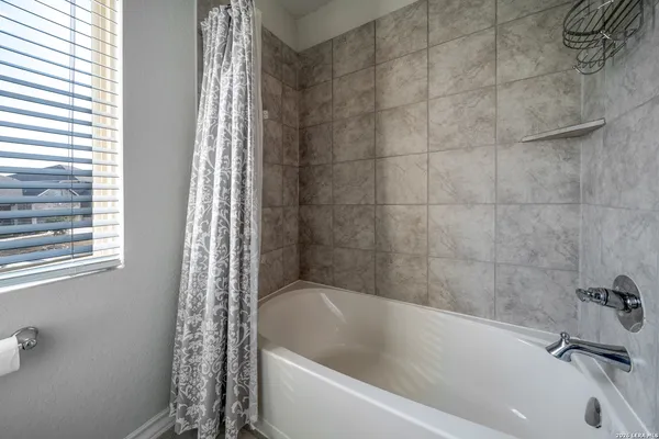 a bath tub sitting next to a white sink and a shower