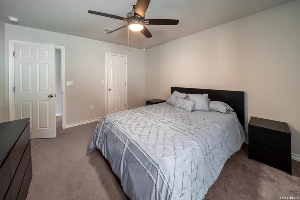 a bedroom with a bed and a ceiling fan