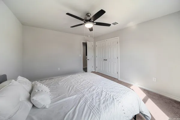a bed room with a bed and a ceiling fan