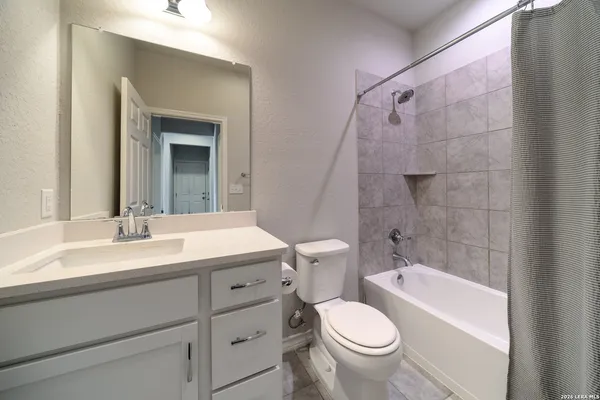 a bathroom with a granite countertop toilet a sink and a bathtub