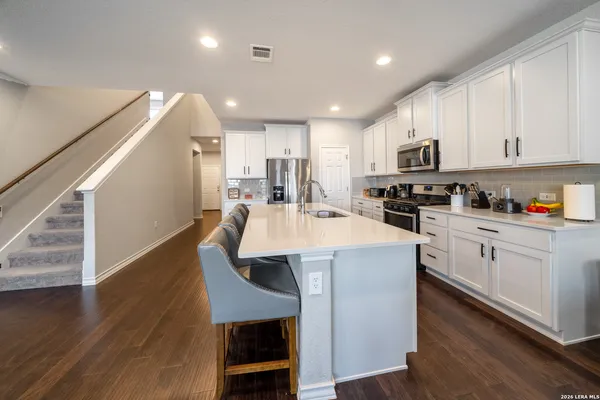 a kitchen with kitchen island a white counter top space cabinets and stainless steel appliances