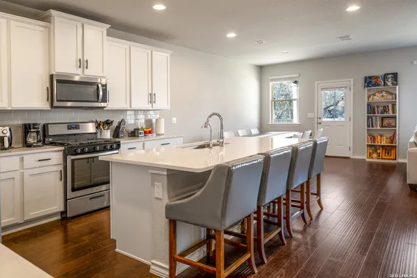 a kitchen with a dining table chairs and white cabinets