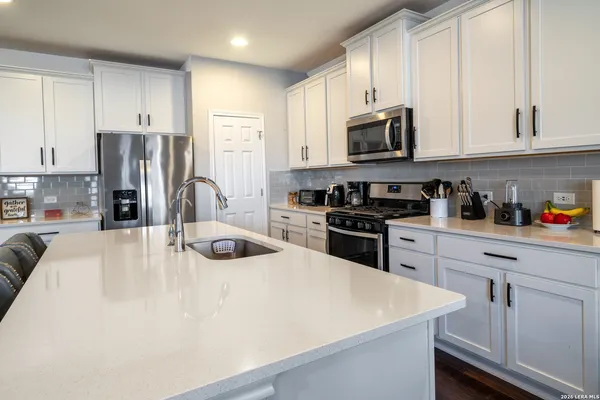 a kitchen with stainless steel appliances a stove sink microwave and cabinets