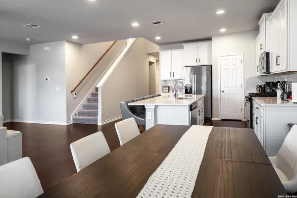 an open kitchen with kitchen island white cabinets and stainless steel appliances