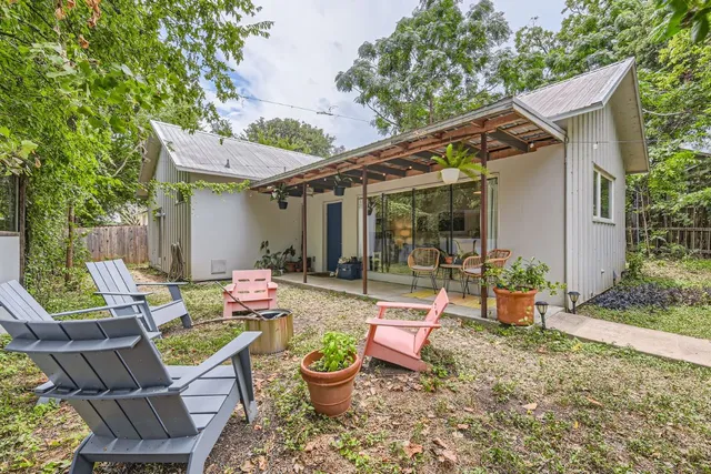 a view of a patio with table and chairs potted plants with wooden fence