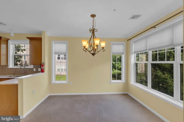 a view of a big room with windows and chandelier