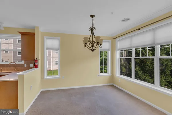 a view of an empty room with a window and chandelier