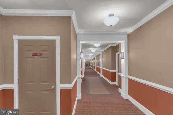 a hallway with wooden floor and chandelier