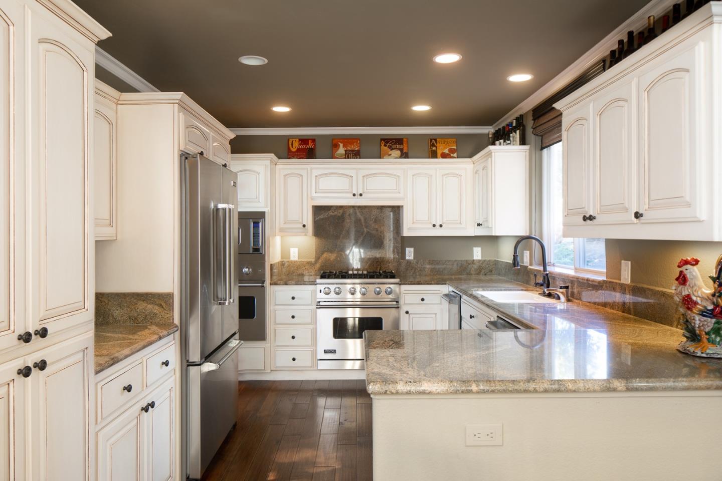 10448 Fairway Lane Carmel, CA 93923 - Photo 6 of 21 a kitchen with granite countertop a refrigerator a sink and white cabinets