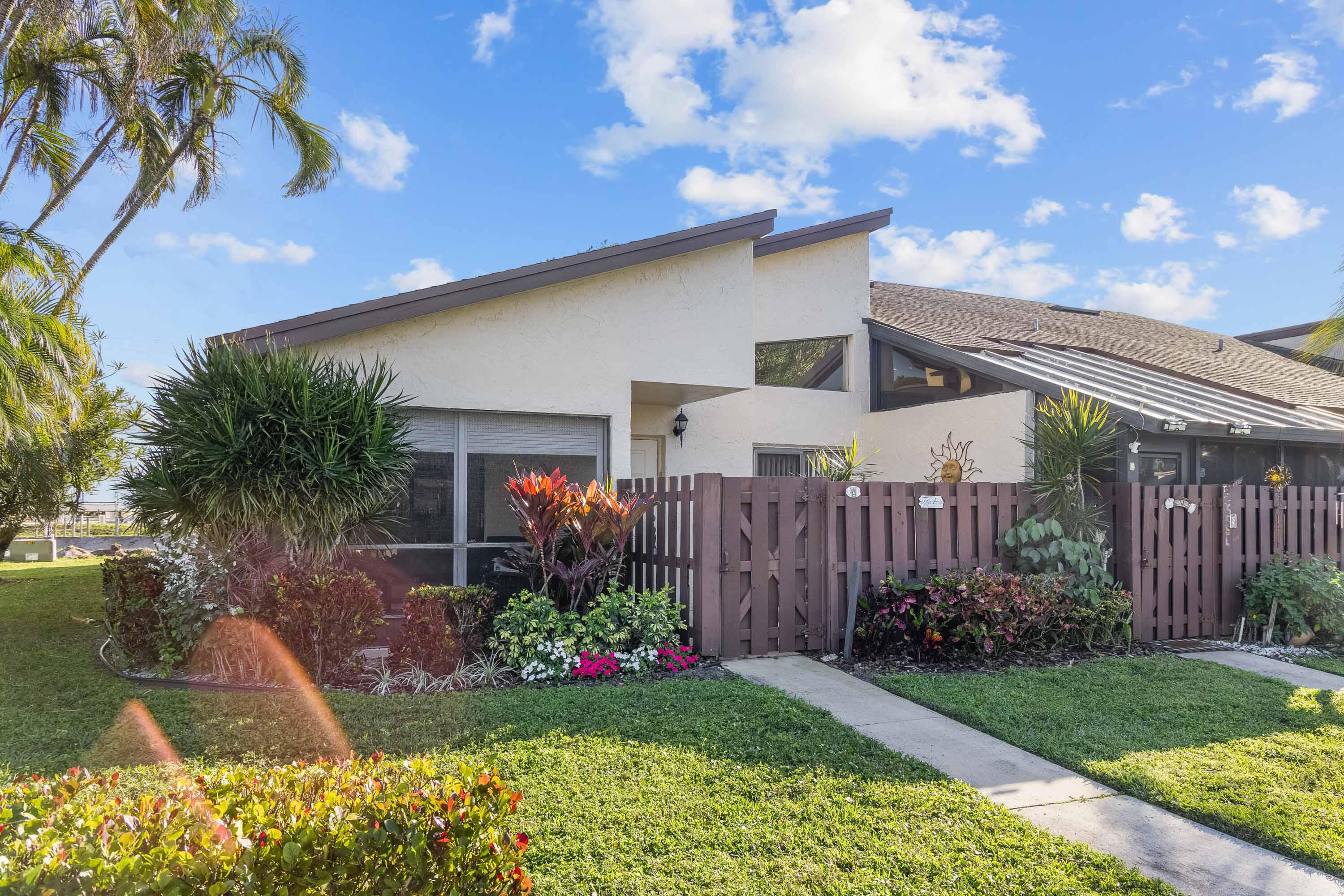 a front view of a house with a yard and potted plants