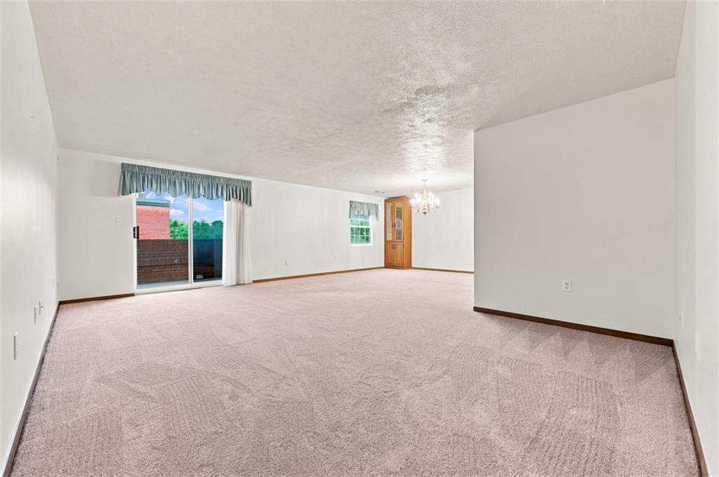 2850 Edgecliff Road, Unit 35 Lower Burrell, PA 15068 - Photo 10 of 28 Spacious living room with sliders to patio. New neutral carpet and view to dining area.