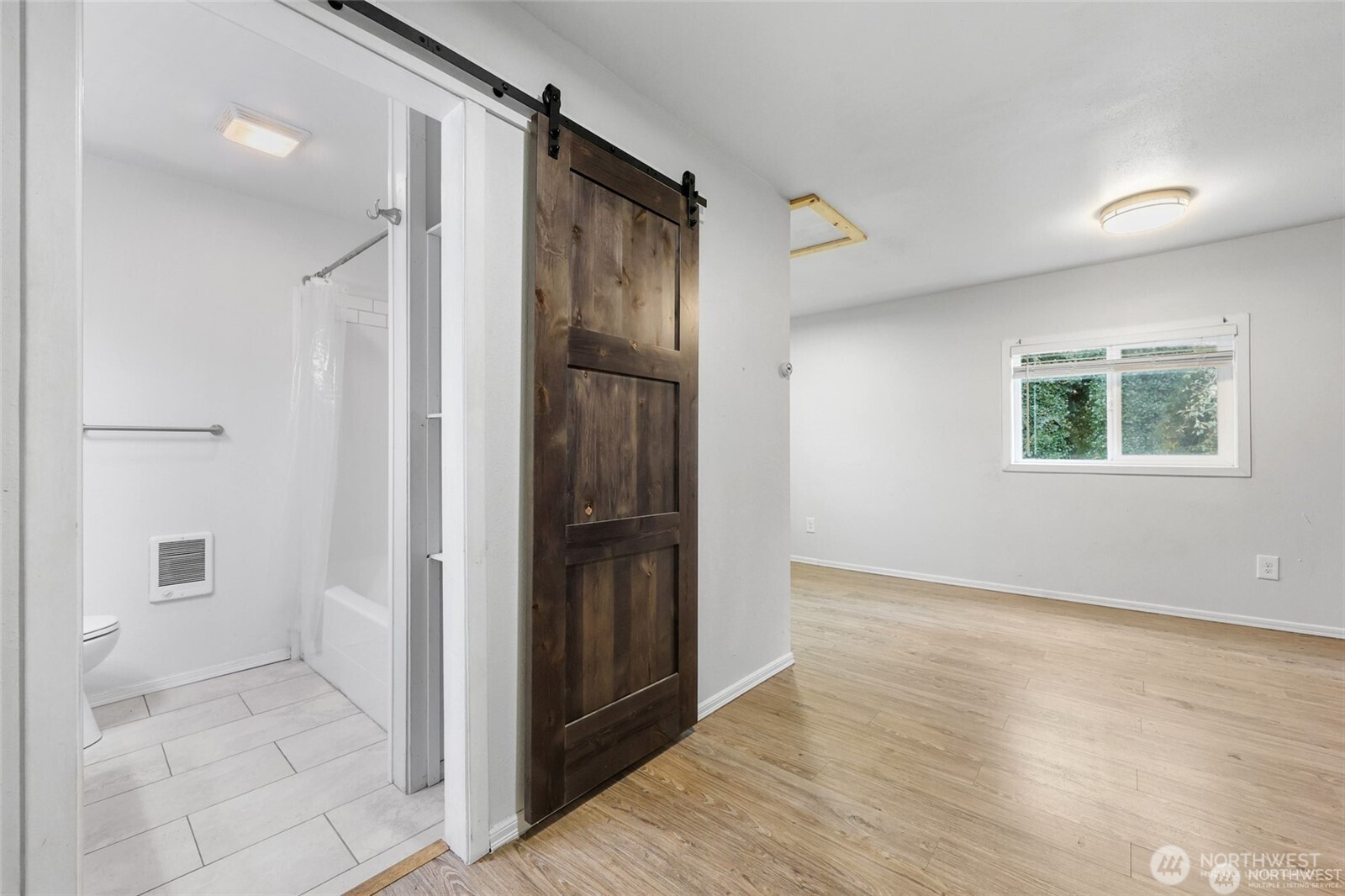 325 East Perry Street Aberdeen, WA 98520 - Photo 17 of 27 an empty room with wooden floor and a bathroom