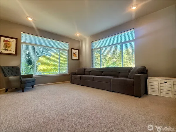 a view of an empty room with furniture and a window