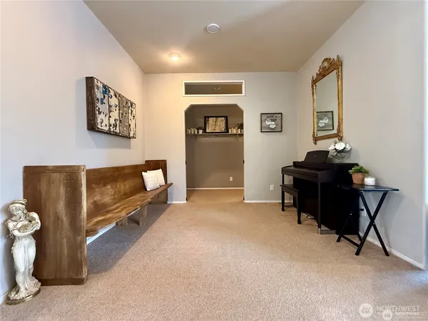 a bedroom with a bed a couch and a flat tv screen on dresser