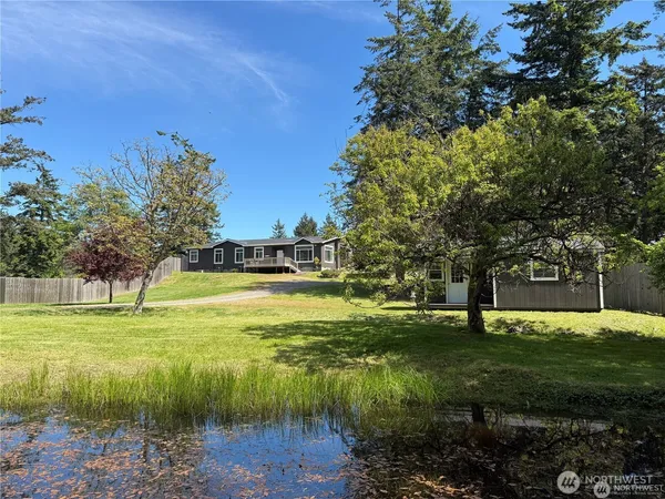 a view of a fountain in front of a house with a yard