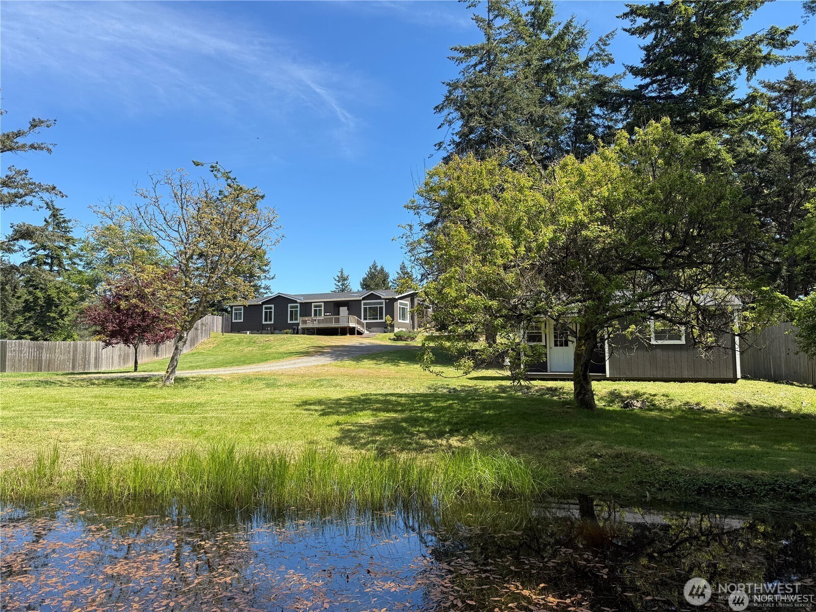168 Jackson Road Orcas Island, WA 98245 - Photo 4 of 40 a view of a fountain in front of a house with a yard