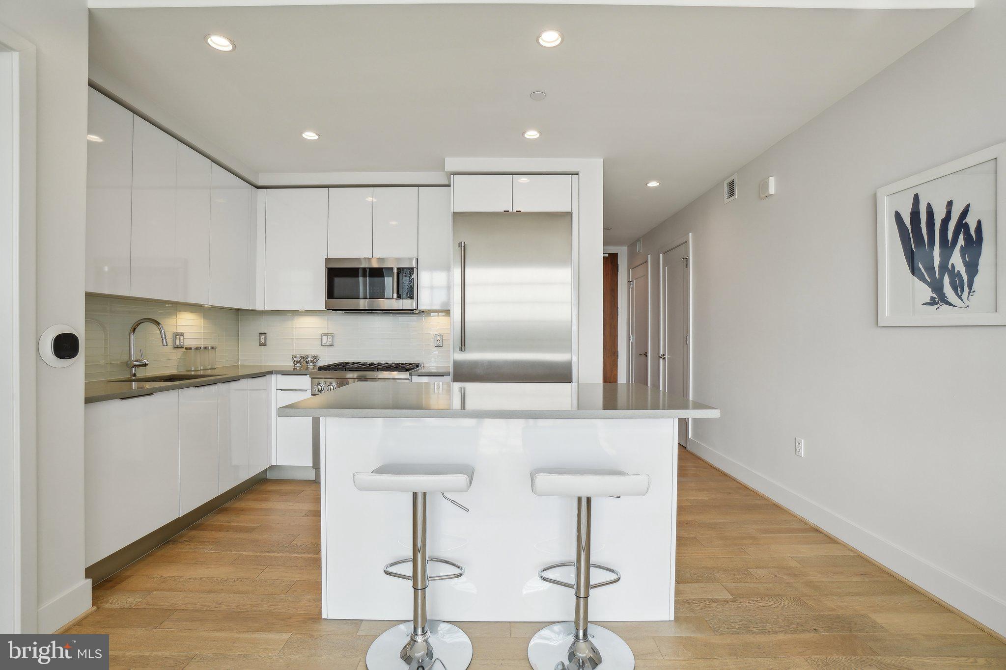 45 Sutton Square Southwest, Unit 602 Washington, DC 20024 - Photo 5 of 35 a kitchen with granite countertop white cabinets and stainless steel appliances