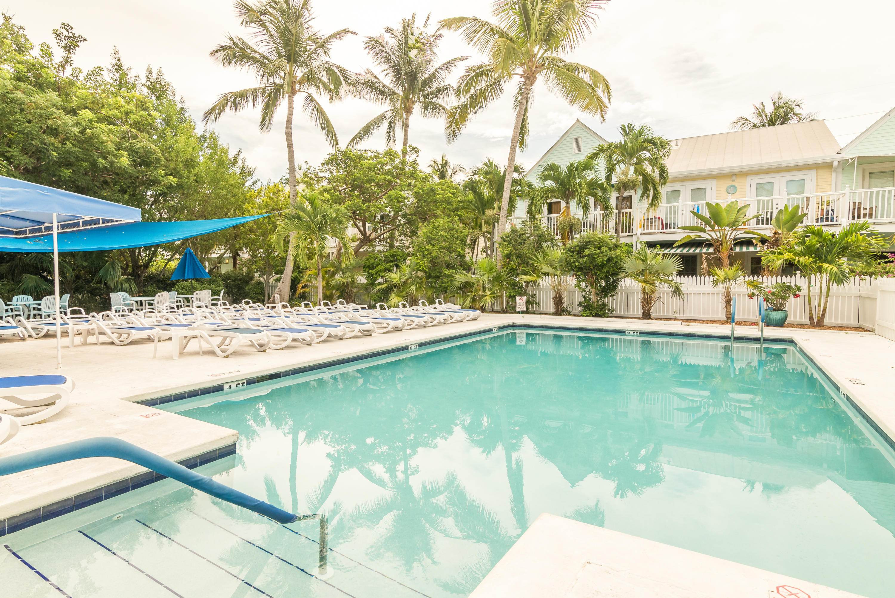 102 Southard Street, Unit 2 Key West, FL 33040 - Photo 23 of 25 a swimming pool with lawn chairs under an umbrella